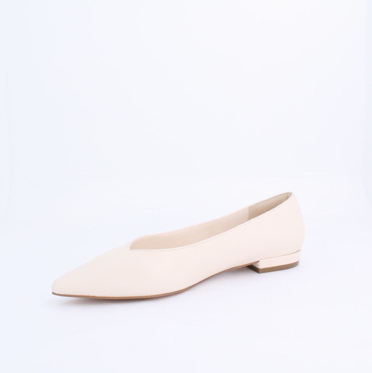 Minimalist cream flat pump style shoe with low heel, perfect for casual or formal outfits. Sophisticated faux leather design.