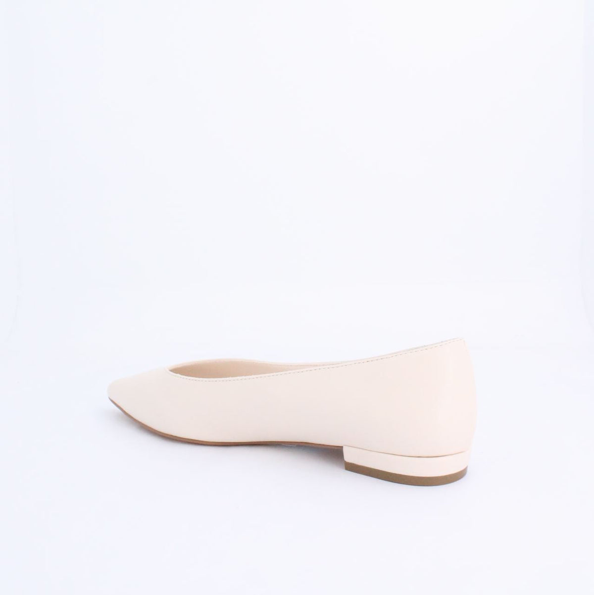 Cream flat pump style shoe with minimalist design and faux leather material, perfect for casual and formal outfits.